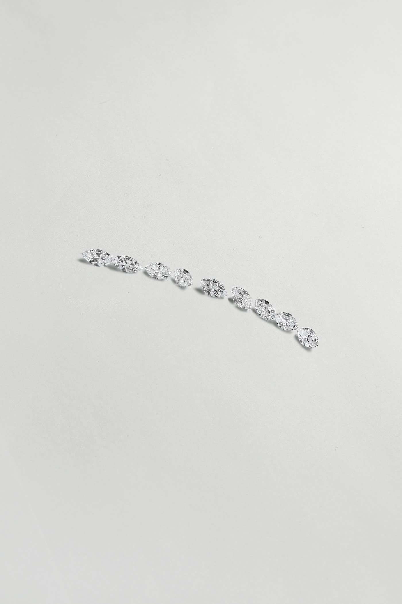 Polished diamonds arranged on a neutral ground