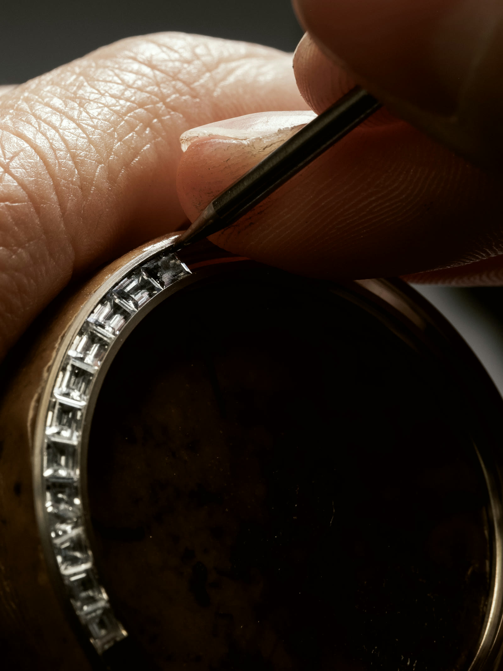 Fine setting tool aligning baguette diamonds in a channel on a watch bezel