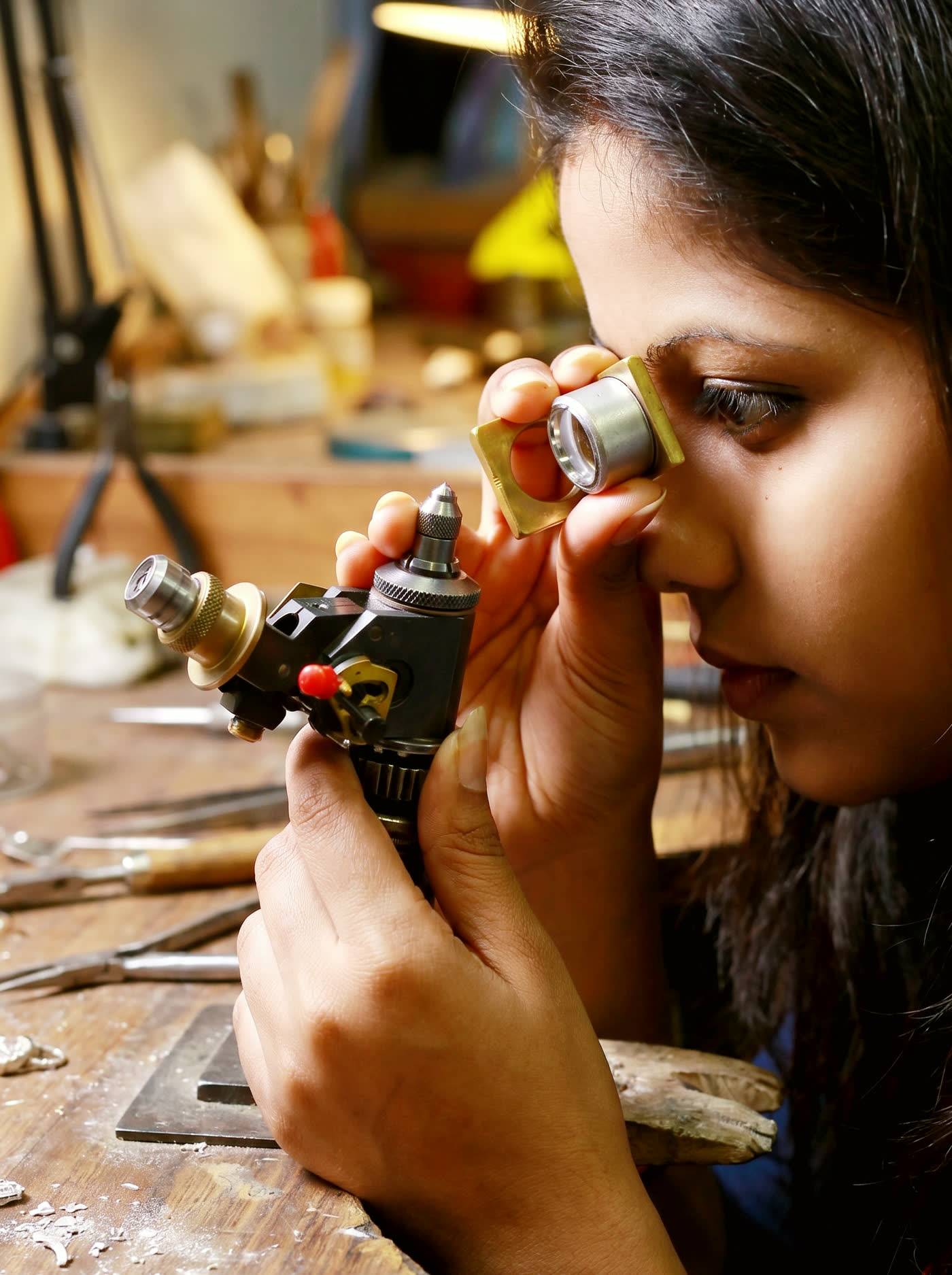 Gemmologist examining a diamond mounted on a dop stick through a loupe at the NIRU internal laboratory