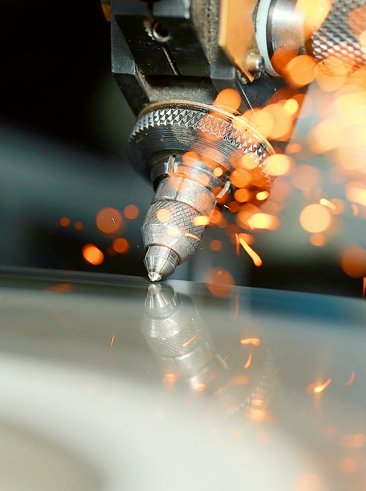 Diamond polishing wheel engaged on the stone, sparks rising from the contact point on the Sri Lankan polishing line